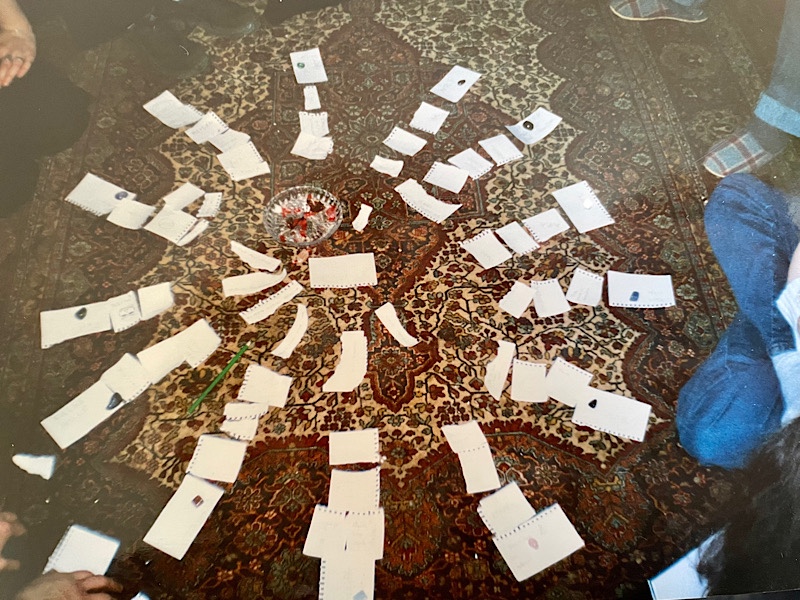 Zettel im Kreis strahlenförmig angeordnet auf gemustertem Teppich 